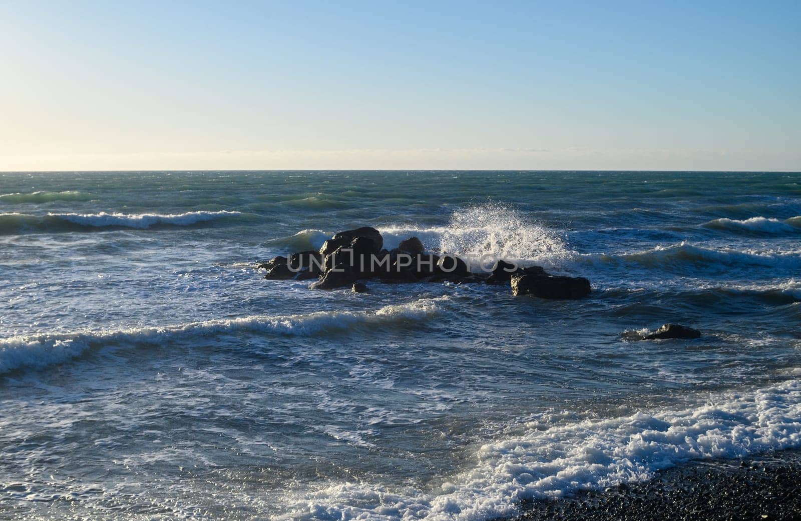 waves crash on large rocks in the Mediterranean Sea near the beach by Mixa74