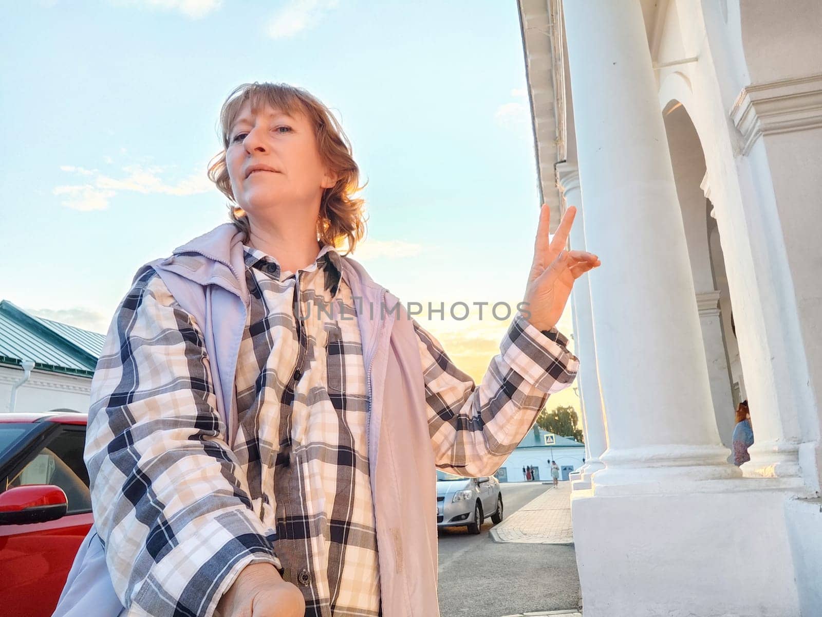 Portrait of middle-aged woman taking selfies in the city. Women's travel tourism. The blogger poses
