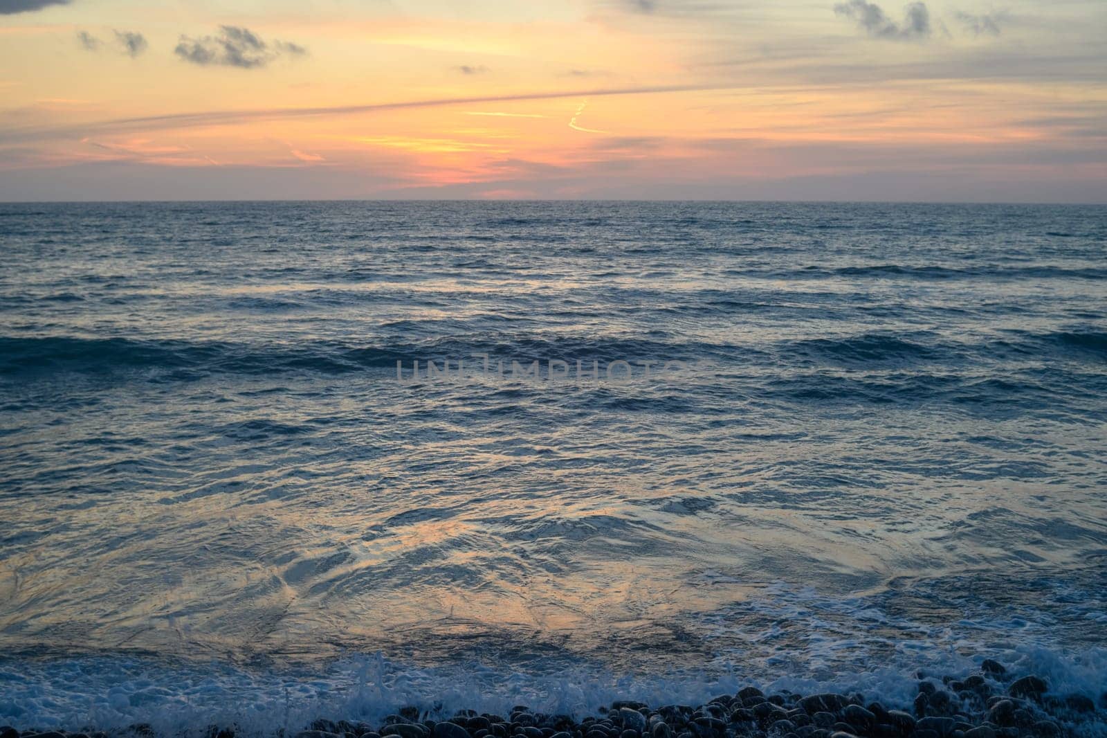 Warm waves of the Mediterranean sea and a sandy beach at sunrise by Mixa74