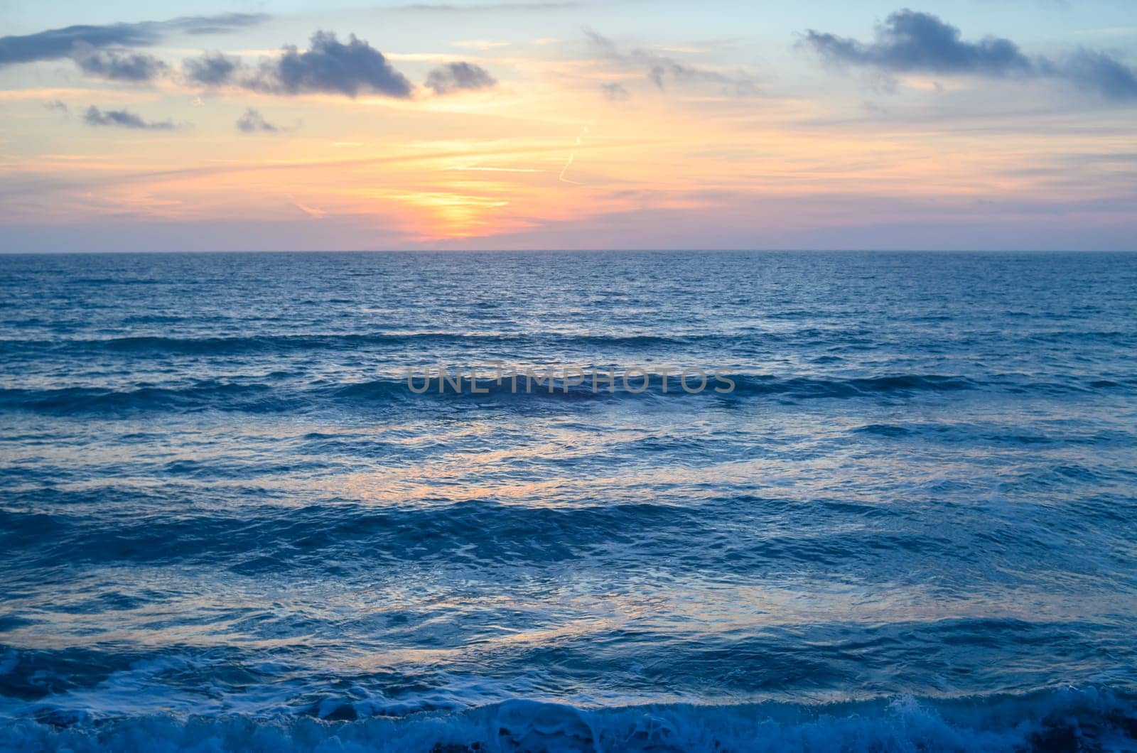 Rocky shoreline bathed in the warm glow of sunset providing a scenic view with copy space image by Mixa74