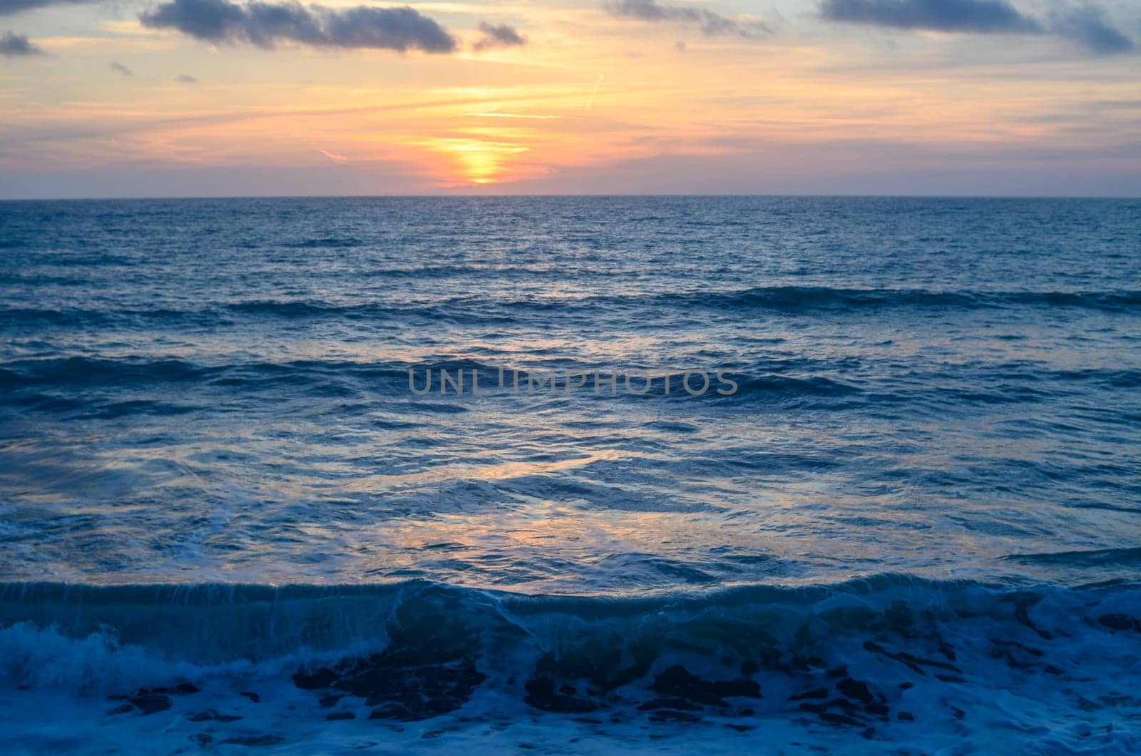 Rocky shoreline bathed in the warm glow of sunset providing a scenic view with copy space image 3