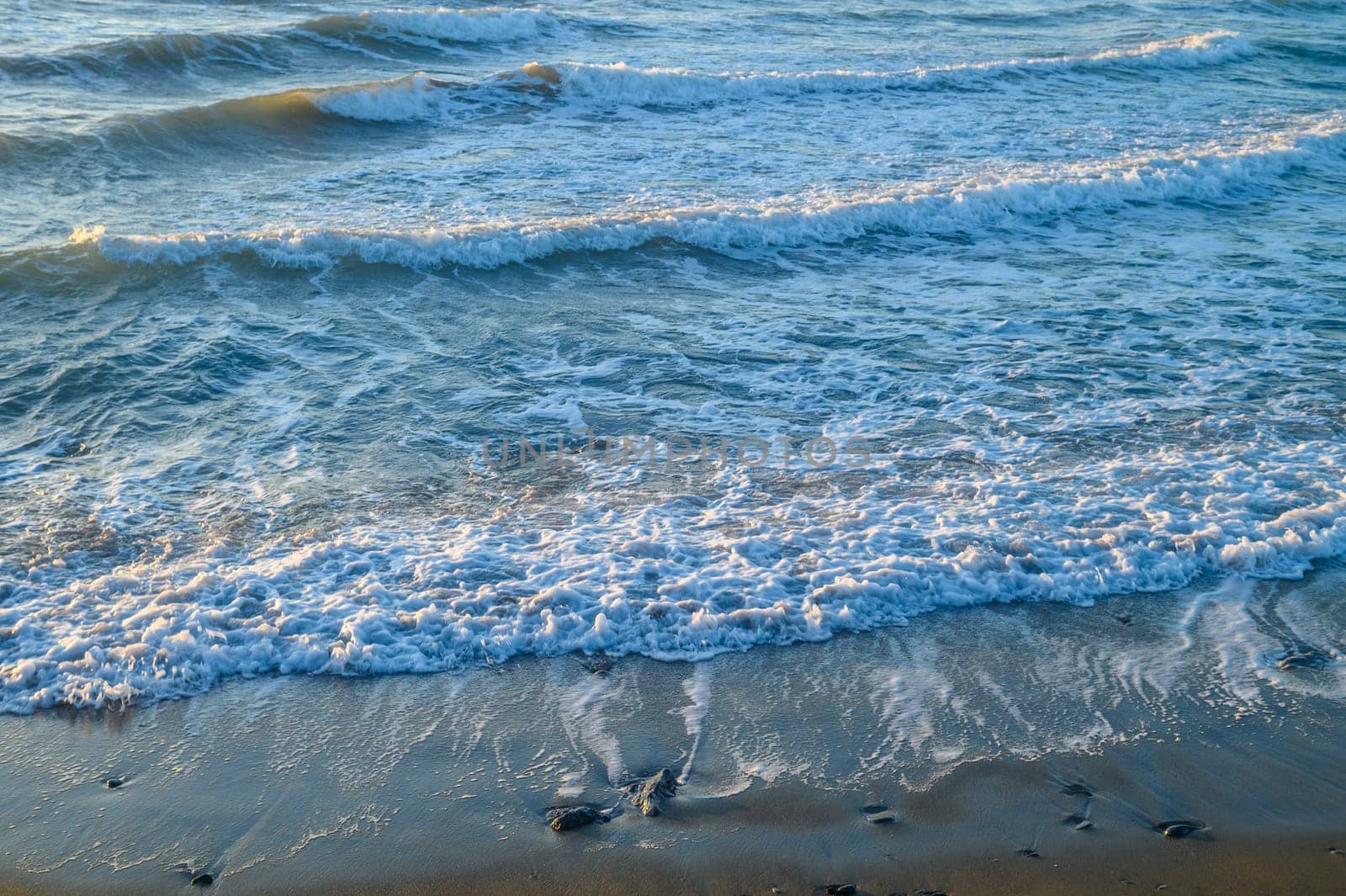 waves and sea foam in the Mediterranean Sea in Cyprus at sunset