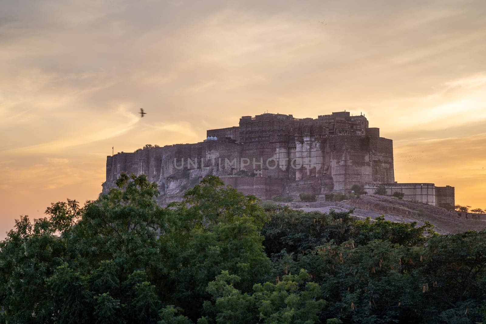 mehrangarh fort in Jodhpur Rajasthan sitting on hilltop surrounded by orange monsoon clouds showing the landmark by Shalinimathur