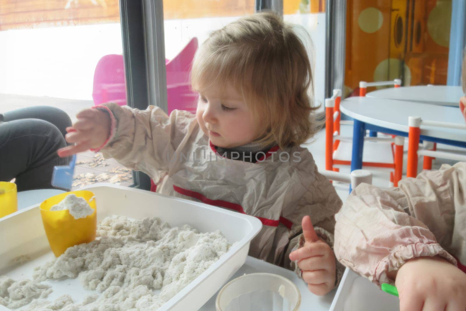 Children in kindergarten playing with kinetic sand