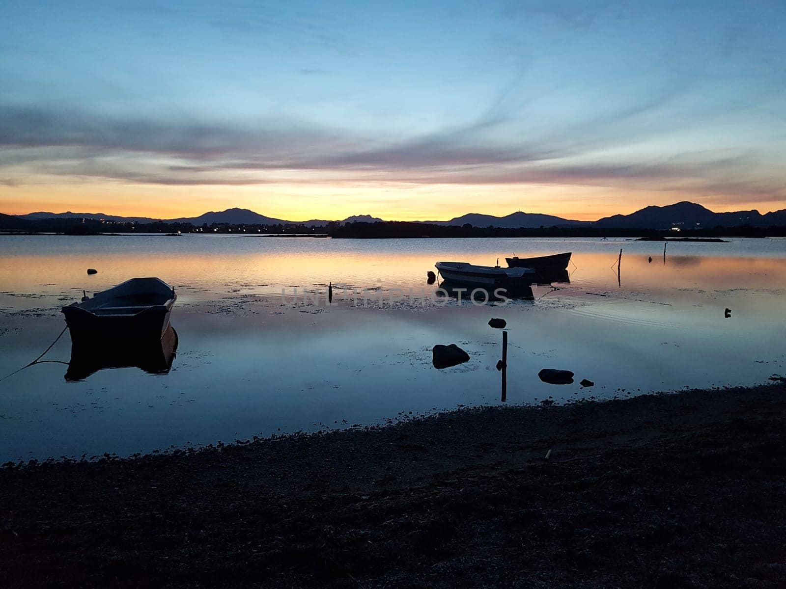 Sunset over a bay with boats on a summer evening in Italy.