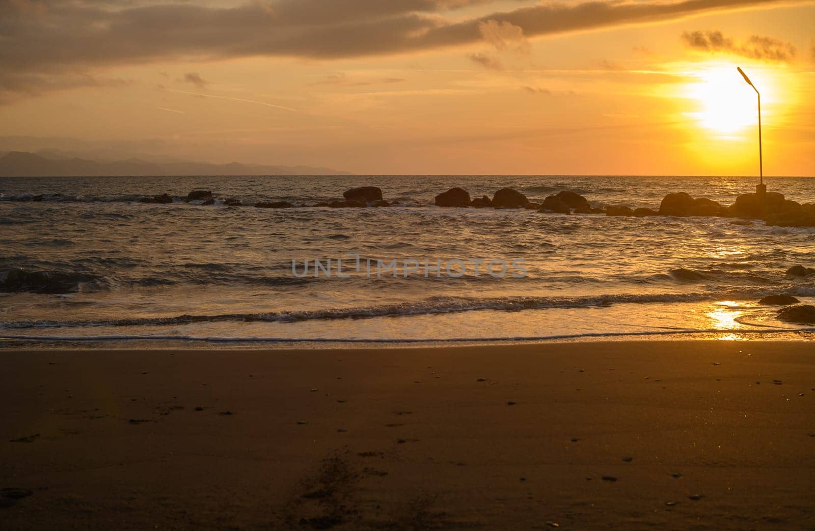 sun glare and radiance on water. sunset seascape with turquoise emerald coloured waves by Mixa74