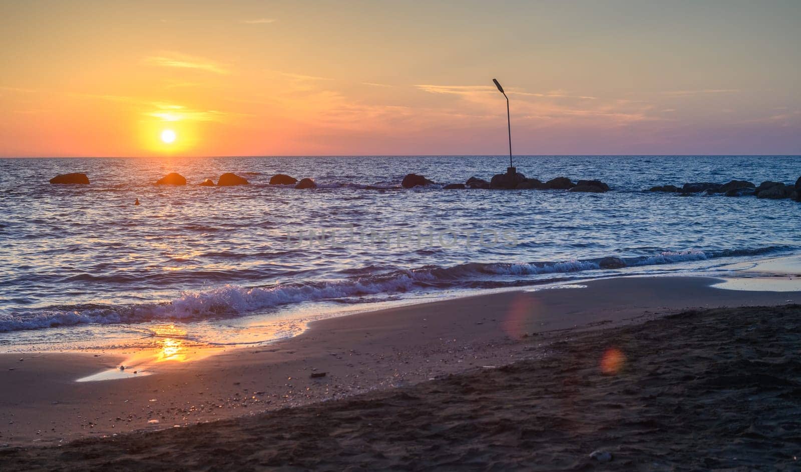 Sunset on pebble beach with sea waves of mediterranean sea 2