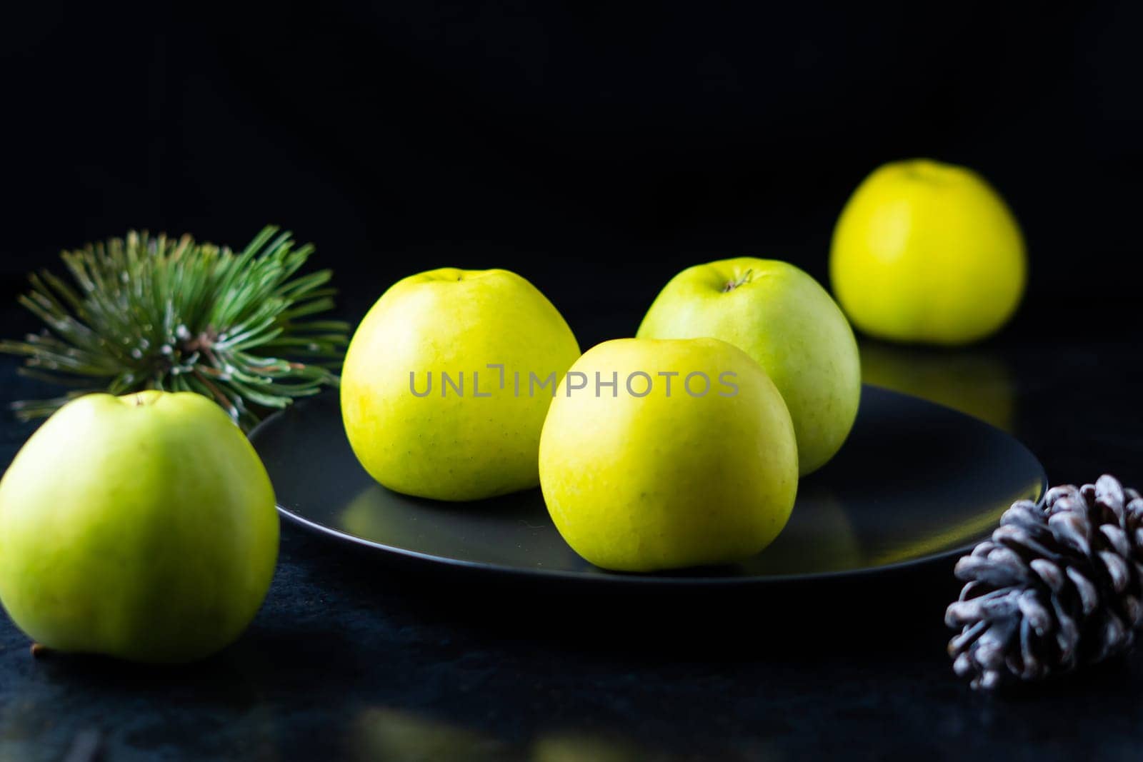 Fresh ripe green apples on a wooden table against dark background, space for text