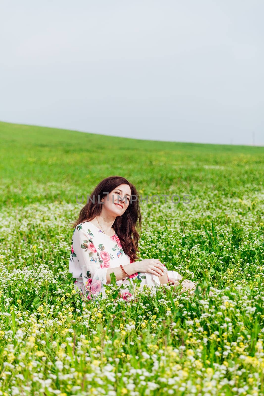 beautiful woman sitting in a green clearing in nature