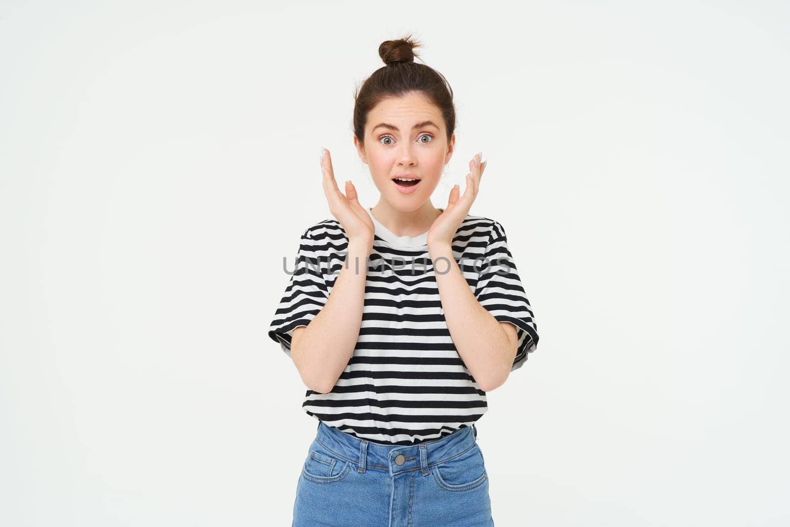 Portrait of surprised woman gasping, looking amazed, hear great news, drops jaw, says wow, impressed by something, stands over white background by Benzoix