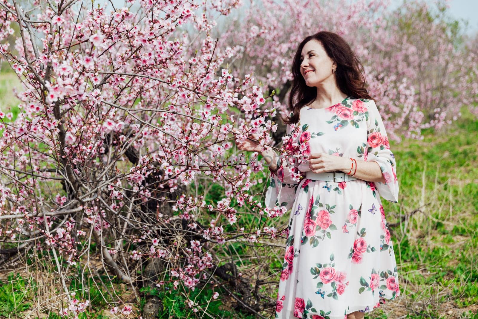 nature park spring woman stands in garden of flowering pink trees