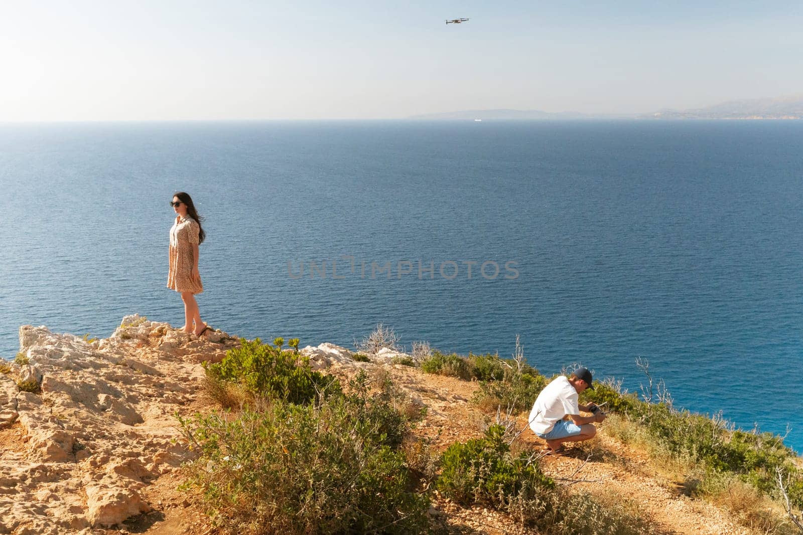 A young couple films a video with a drone near the sea. by Nataliya