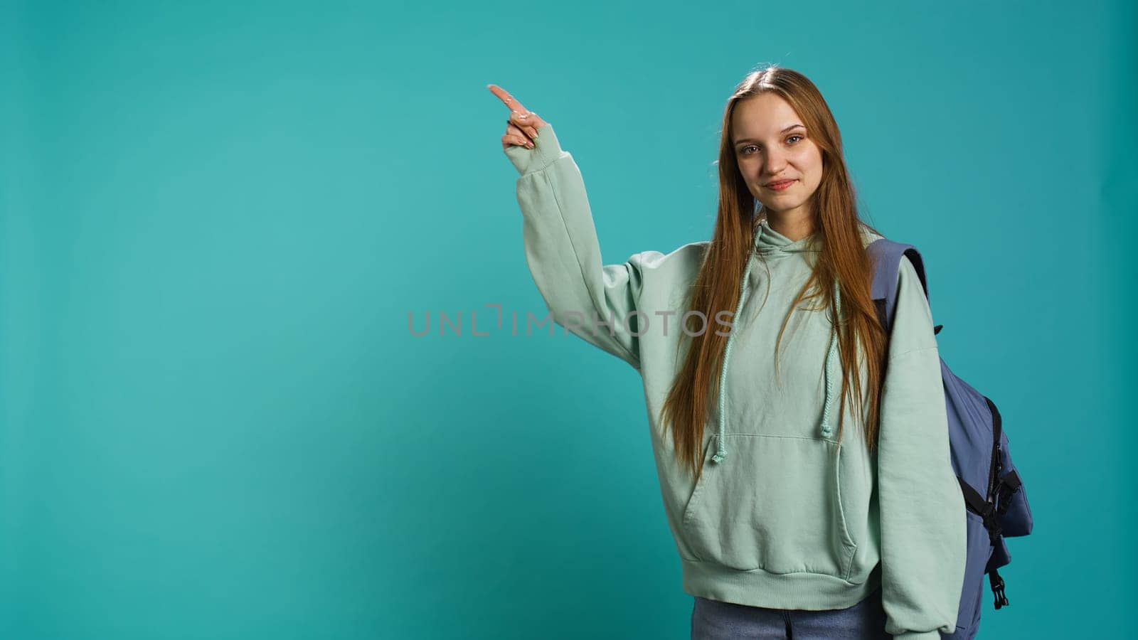 Portrait of cheerful person pointing finger towards empty copy space by DCStudio