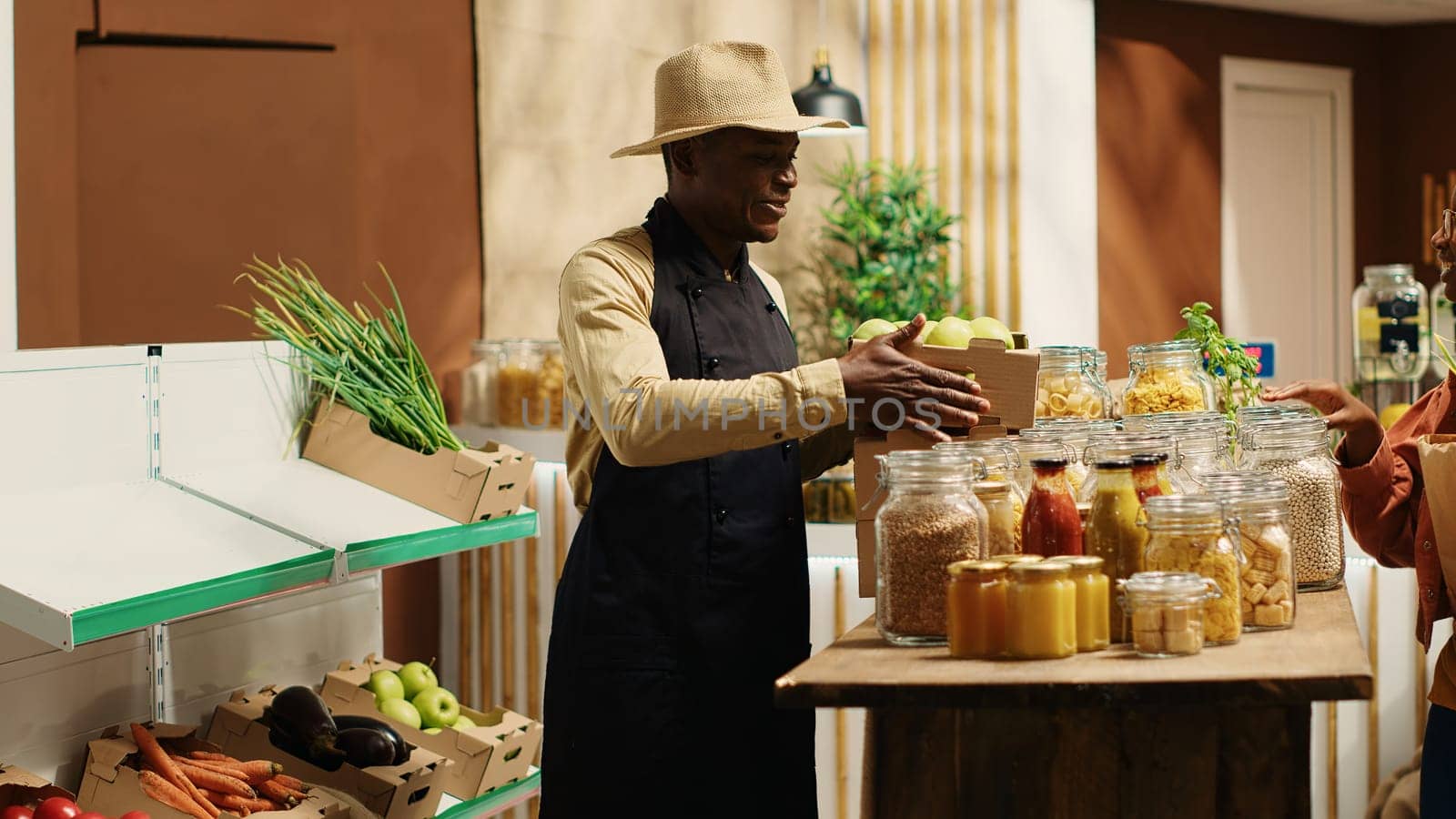 Local vendor placing crates with freshly harvested fruits on grocery store by DCStudio