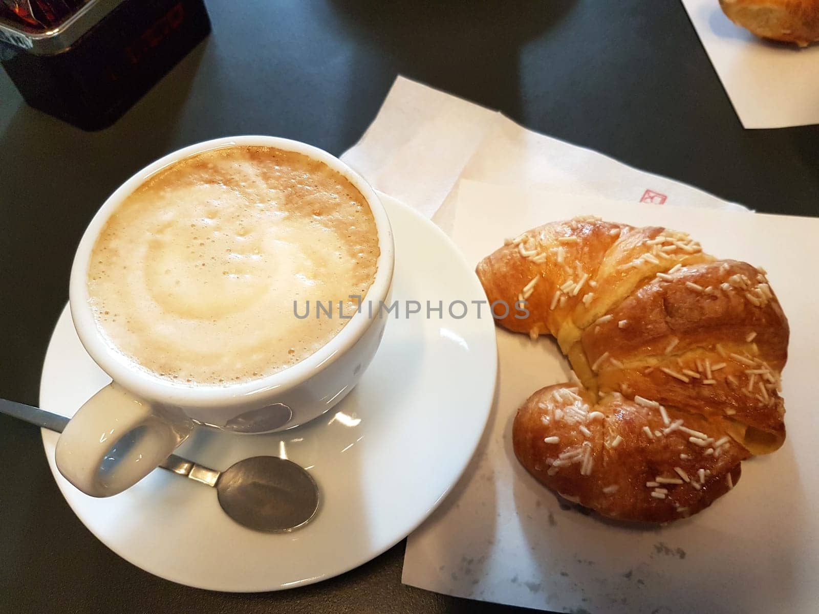 A traditional Italian breakfast with croissant and creamy cappuccino.
