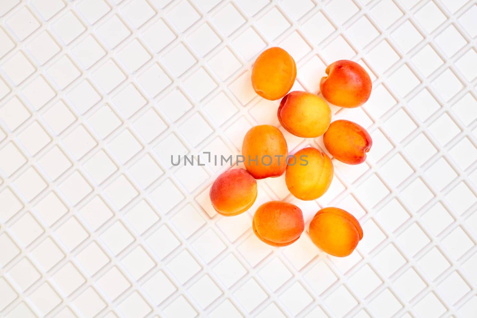 Taste of summer.Fresh ripe apricot fruits isolated on white plastic checkered by jovani68