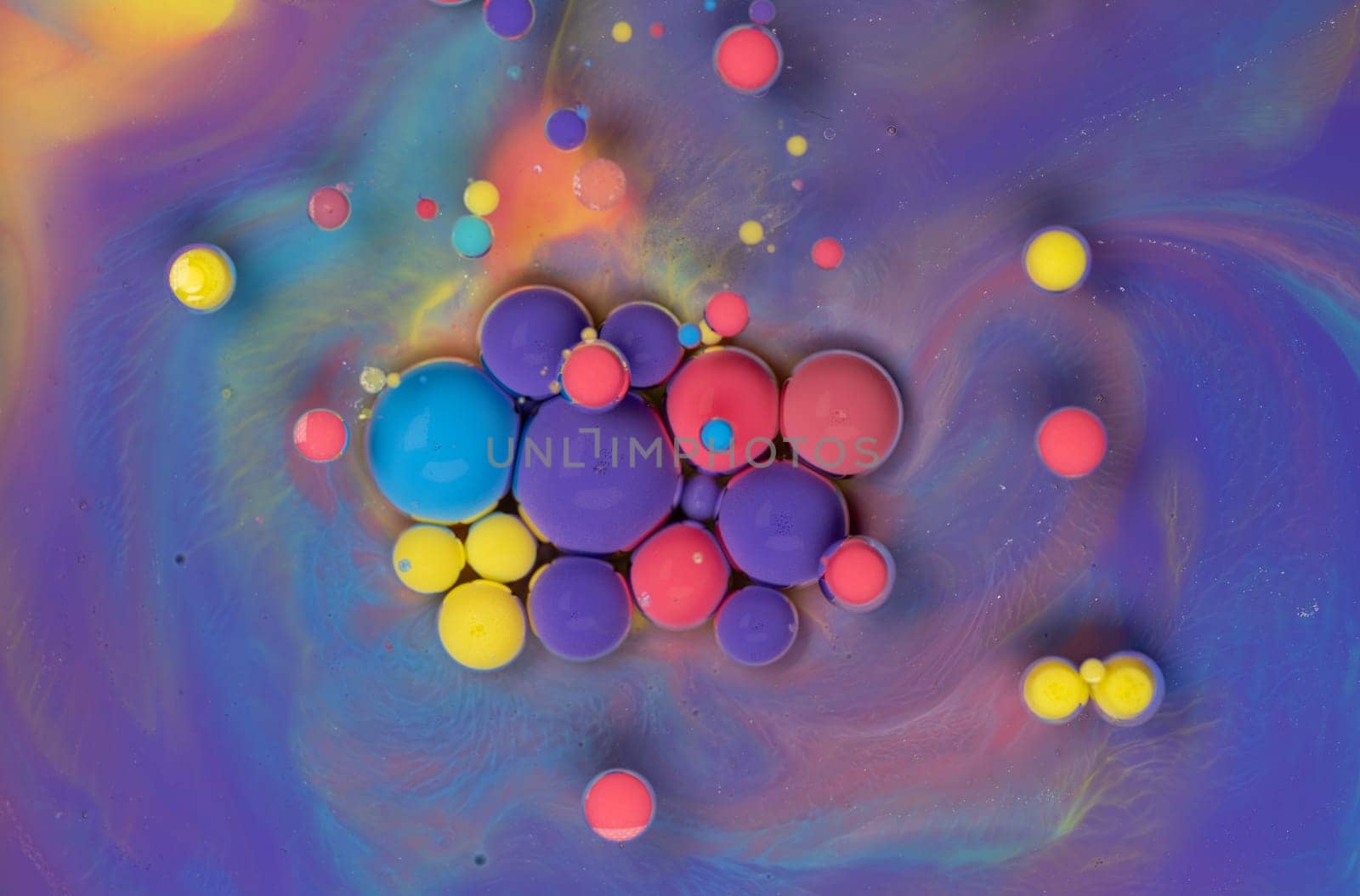 A close-up photograph showcasing a mesmerizing array of colorful bubbles suspended in a liquid medium, creating a stunning abstract composition. The bubbles exhibit a vibrant spectrum of hues.