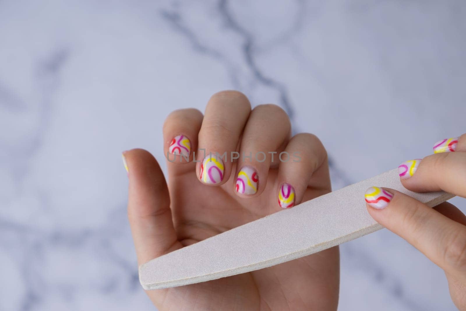 Manicure tools Pastel softness colorful manicured nails. Woman showing her new summer manicure in colors of pastel palette. Simplicity decor fresh spring vibes earth-colored neutral tones design