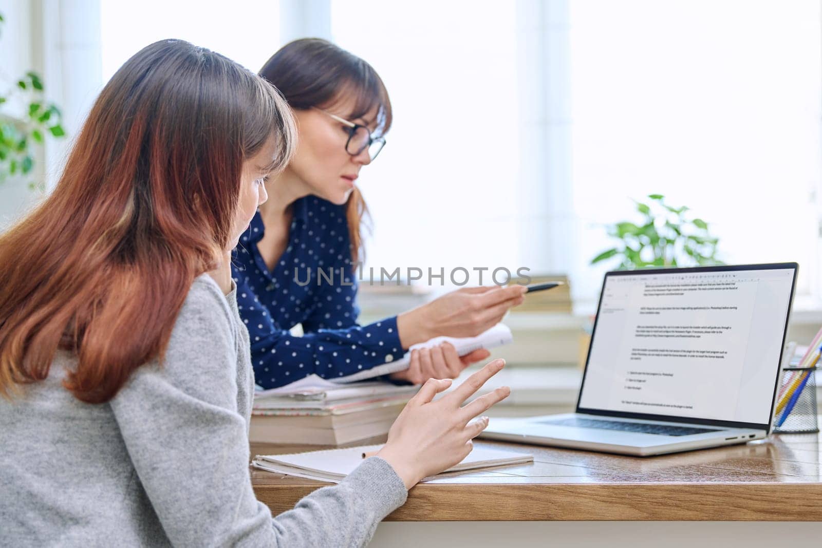 Female teacher mentor teaching young teenage girl student using laptop computer by VH-studio