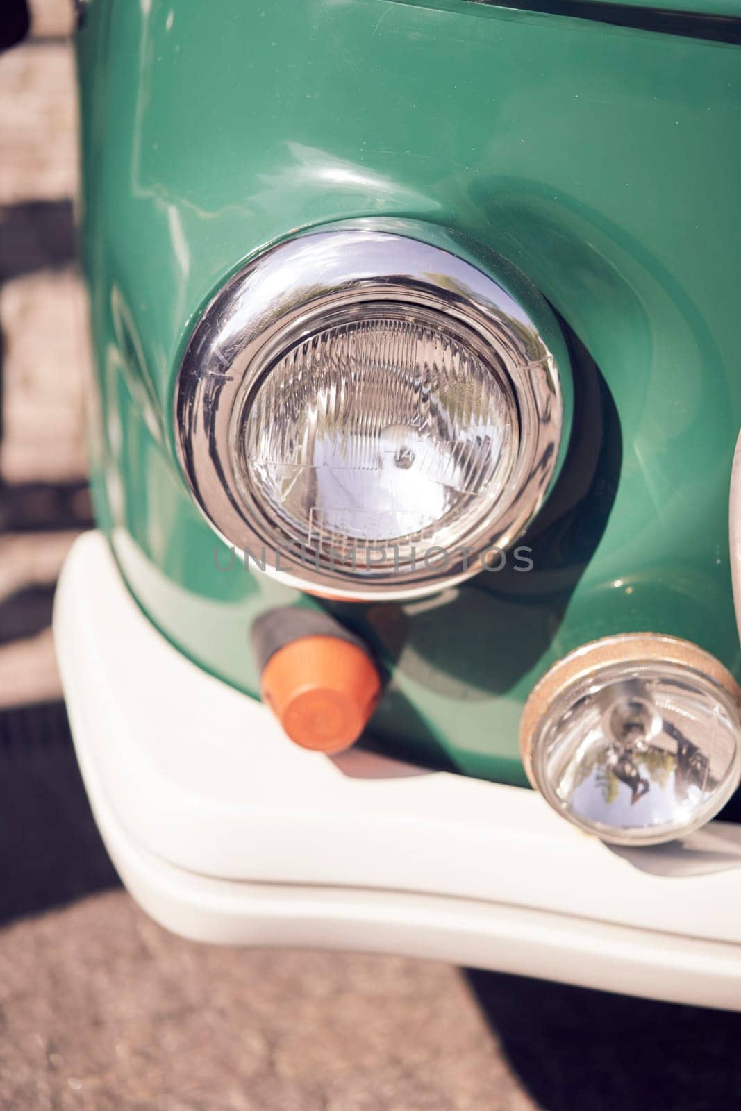 Closeup of vintage cars headlight and chrome bumper, showcasing classic automotive design details