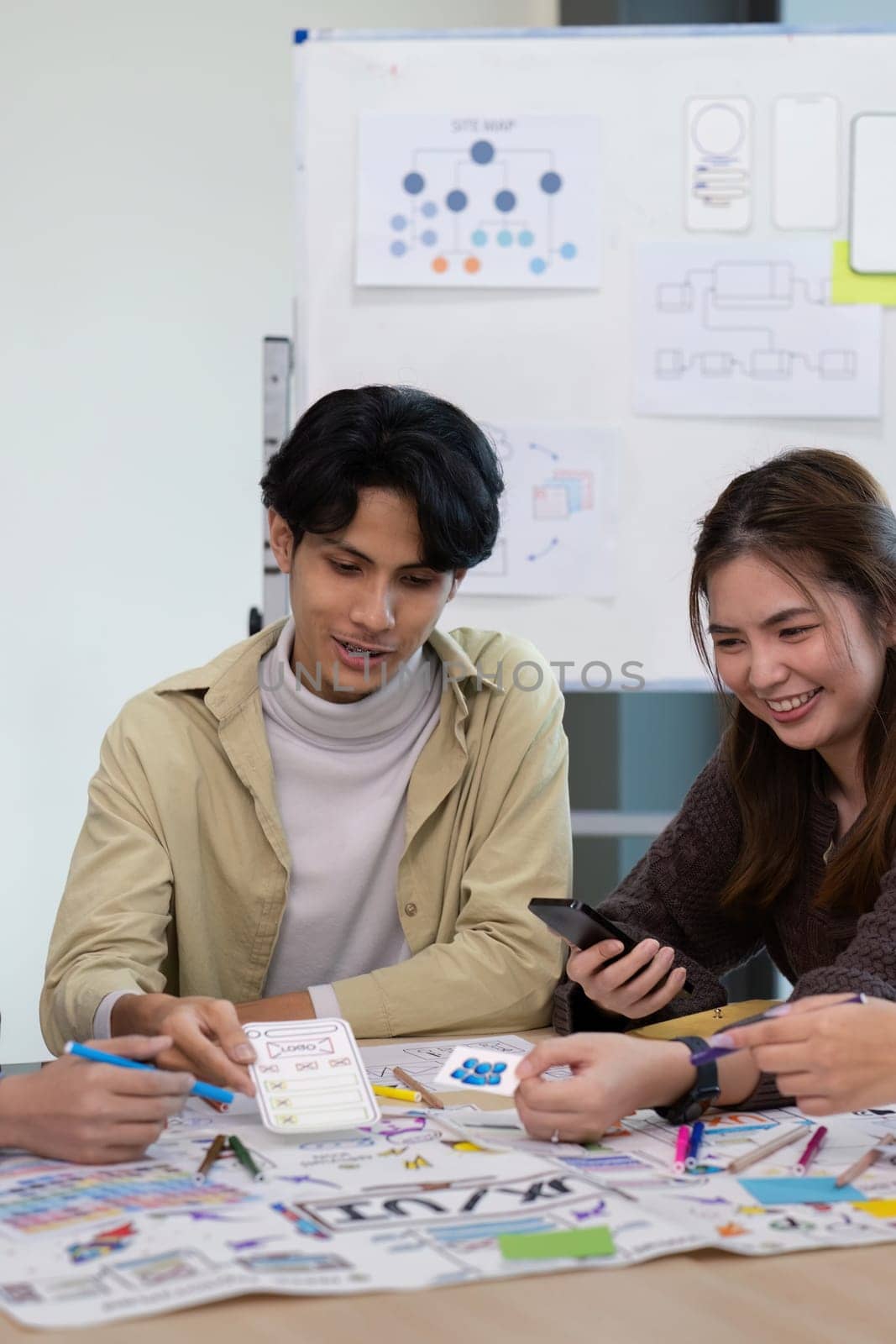 UX developer and UI designer collaborating in a brainstorming session, discussing wireframes and prototypes for innovative digital solutions.