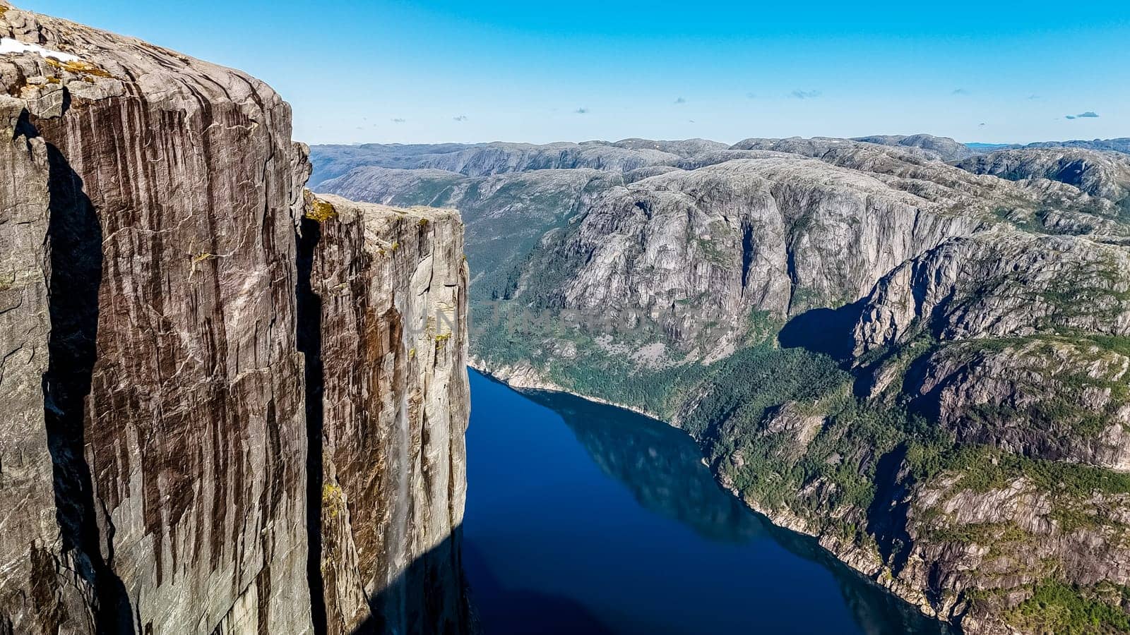 A breathtaking panoramic view of the Kjeragbolten, Norway cliff in Norway, showcasing its towering height and the stunning natural beauty of the surrounding landscape.