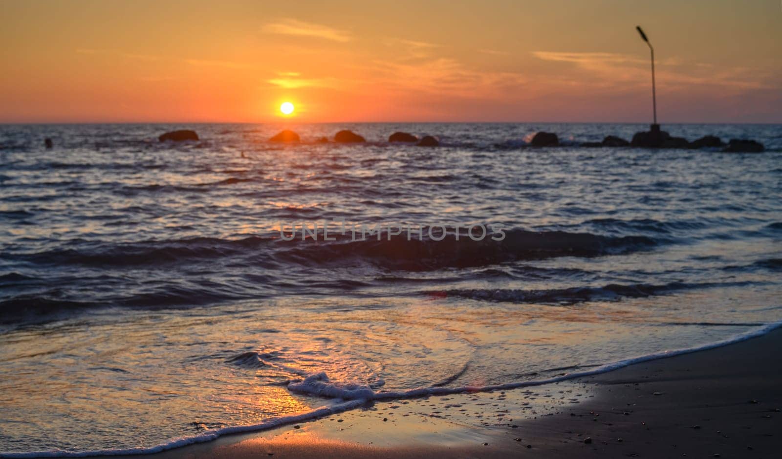 sea, clouds, mountains and waves on the Mediterranean coast on the island of Cyprus at sunset