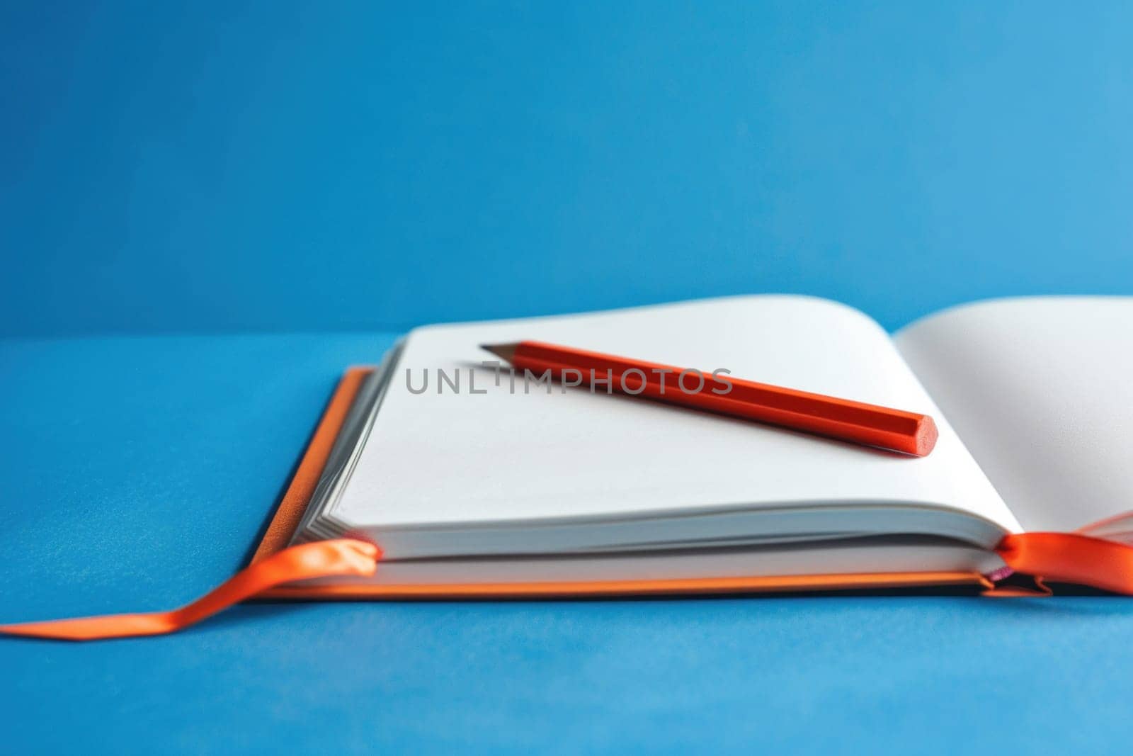 Open notebook with orange pen on blue background creativity and inspiration for business and travel planning