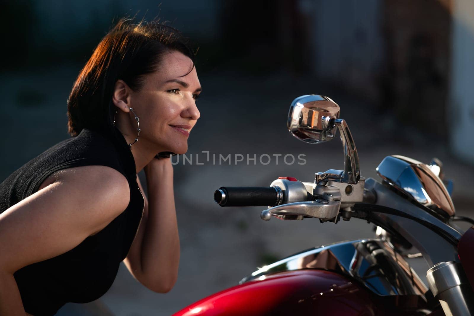 Brunette woman looks in the rearview mirror on a motorcycle