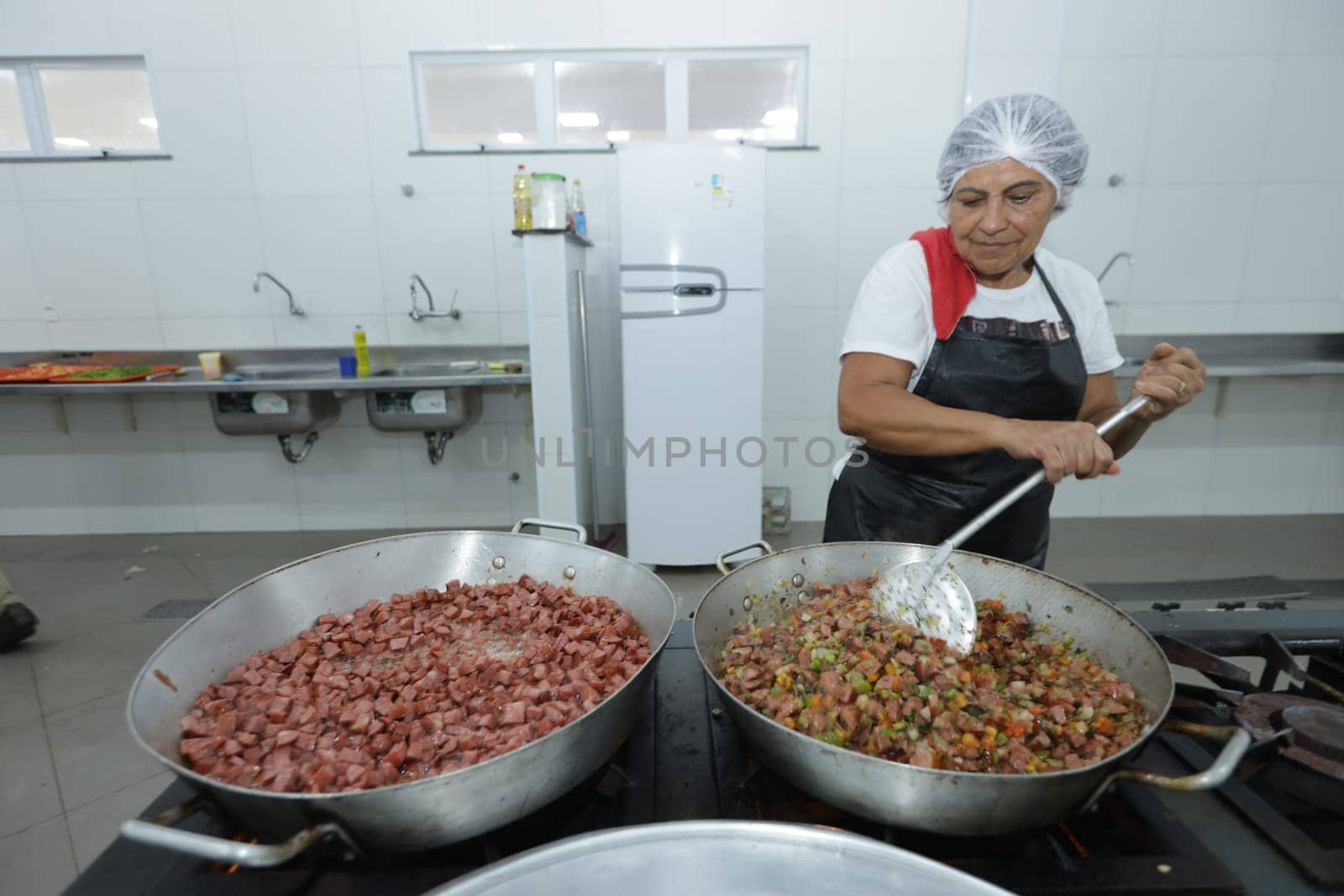 salvador, bahia, brazil - may 17, 2024: cooks prepare food in a kitchen at a public school in Bahia.