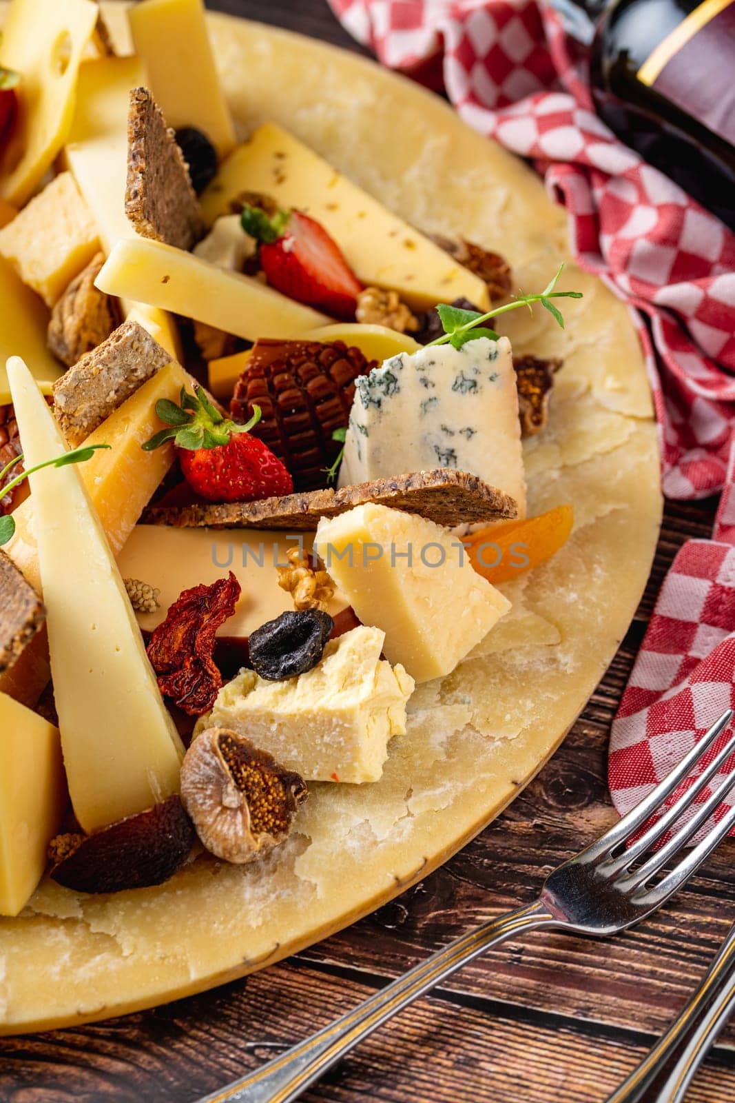 Cheese plate prepared with luxury cheeses and wine on wooden table by Sonat