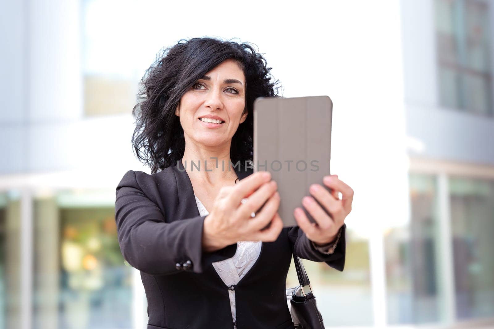 Smiling caucasian businesswoman with digital tablet outdoors. by mariaphoto3