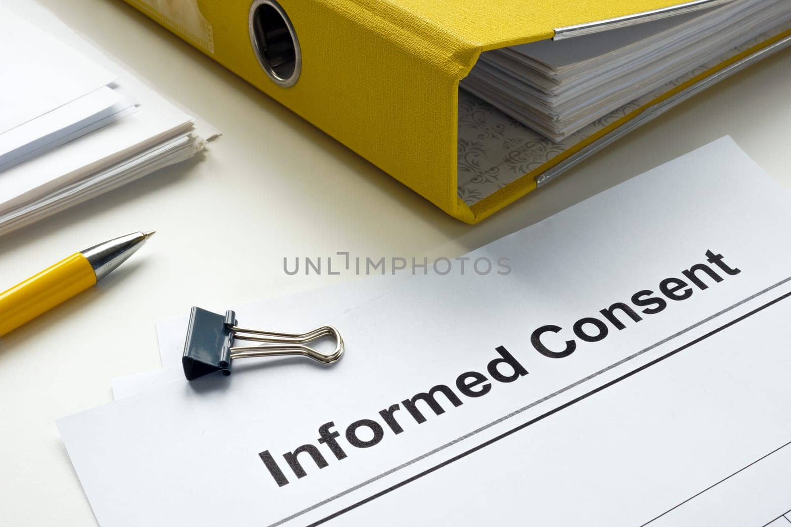 Informed consent documents and a yellow folder.