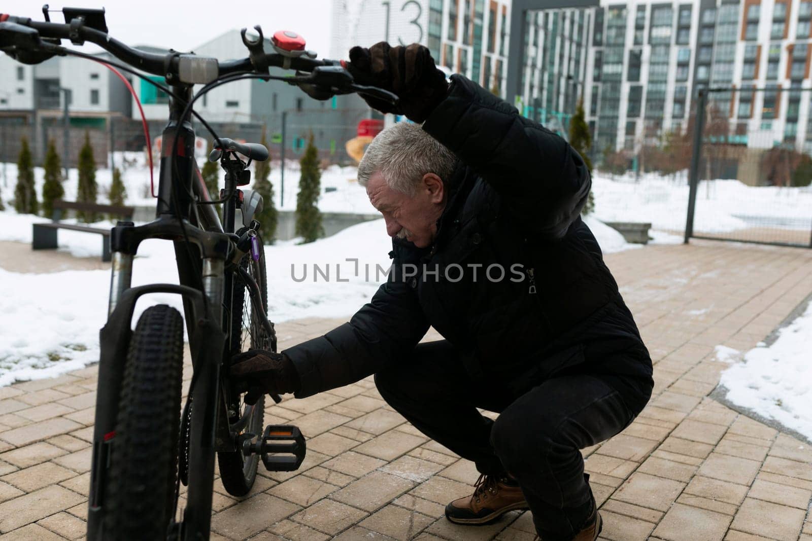 Senior man checking the operation of a bicycle on the street.