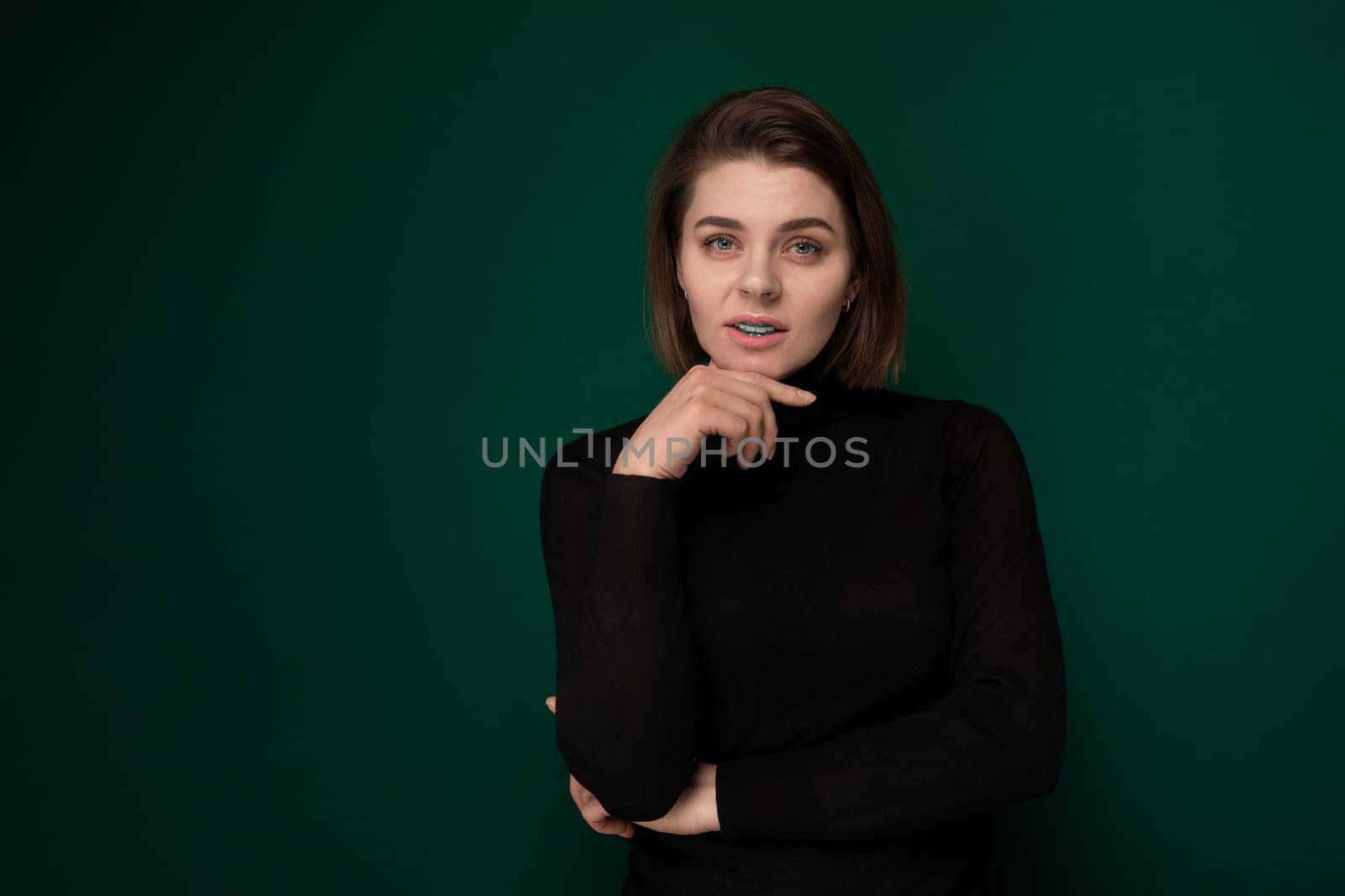 A woman wearing a black shirt is striking a pose for a photograph. She appears confident and stylish as she poses in front of the camera, showcasing her sense of fashion.