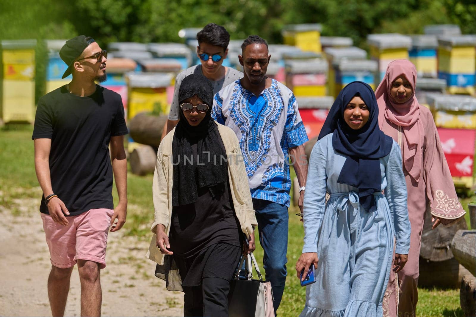 A diverse group of young friends and entrepreneurs explore small honey production businesses in the natural setting of the countryside. by dotshock