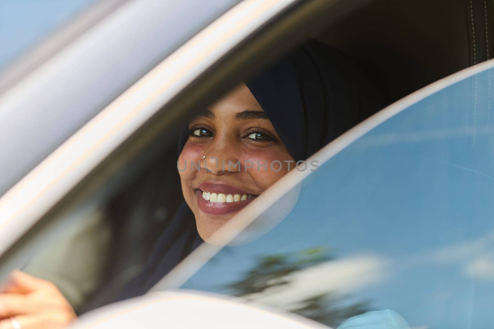 A Middle Eastern teenage girl enjoys a drive through scenic nature, embracing the freedom and beauty of the outdoors.