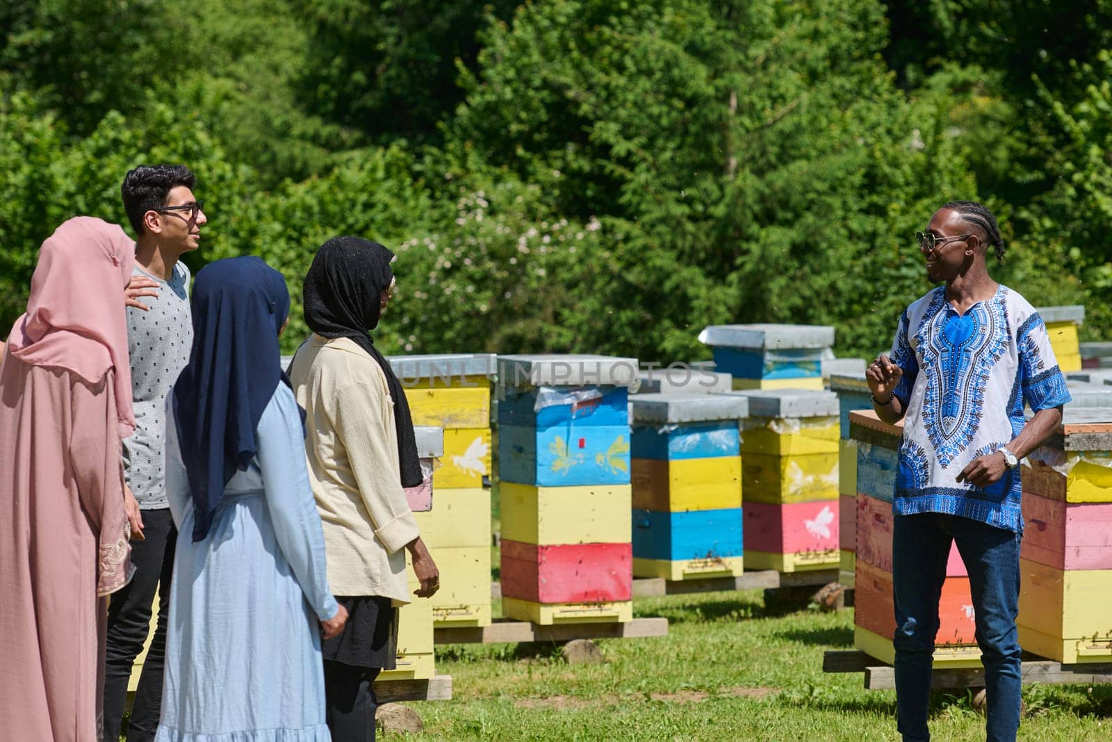 A diverse group of young friends and entrepreneurs explore small honey production businesses in the natural setting of the countryside. by dotshock