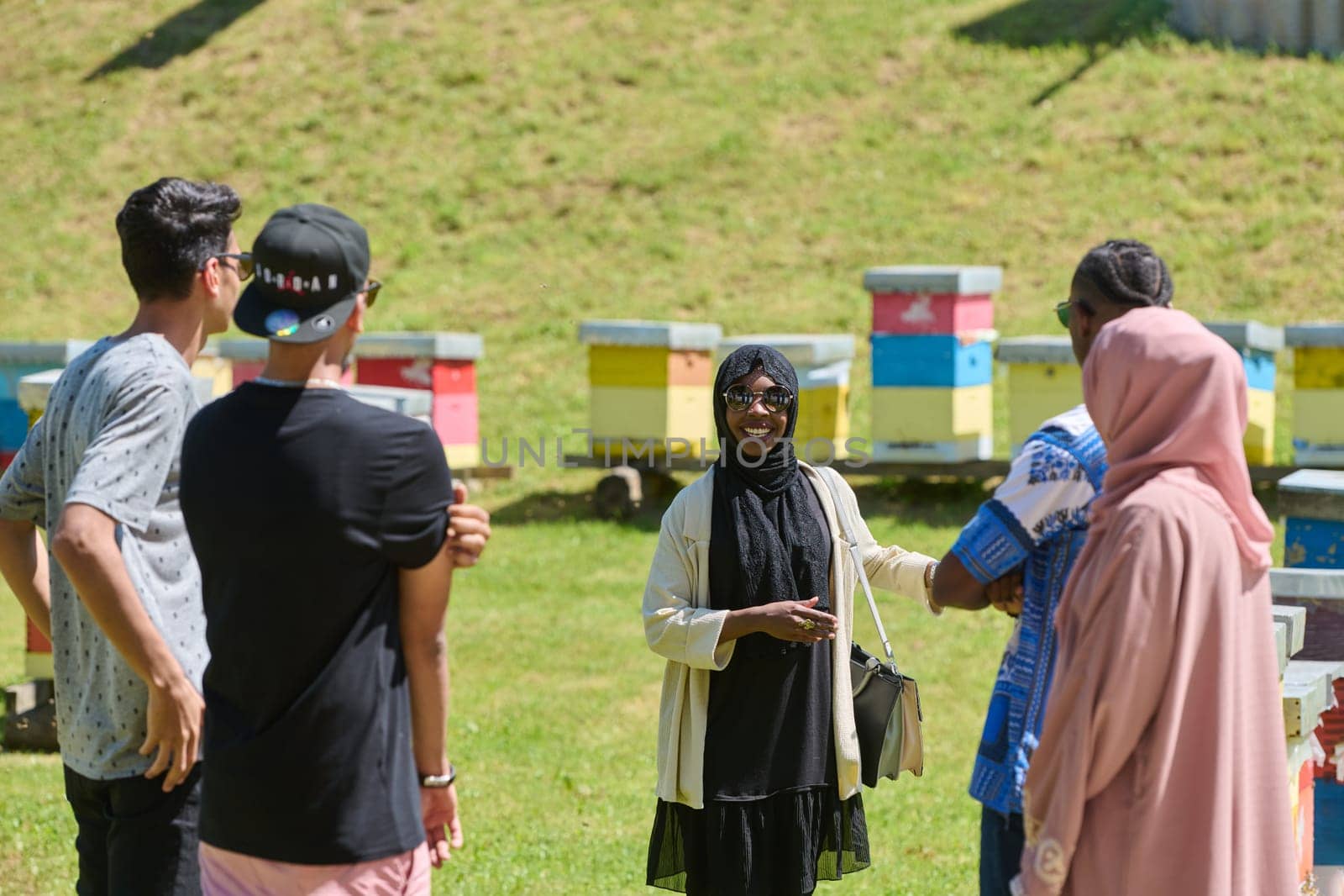 A diverse group of young friends and entrepreneurs explore small honey production businesses in the natural setting of the countryside. by dotshock