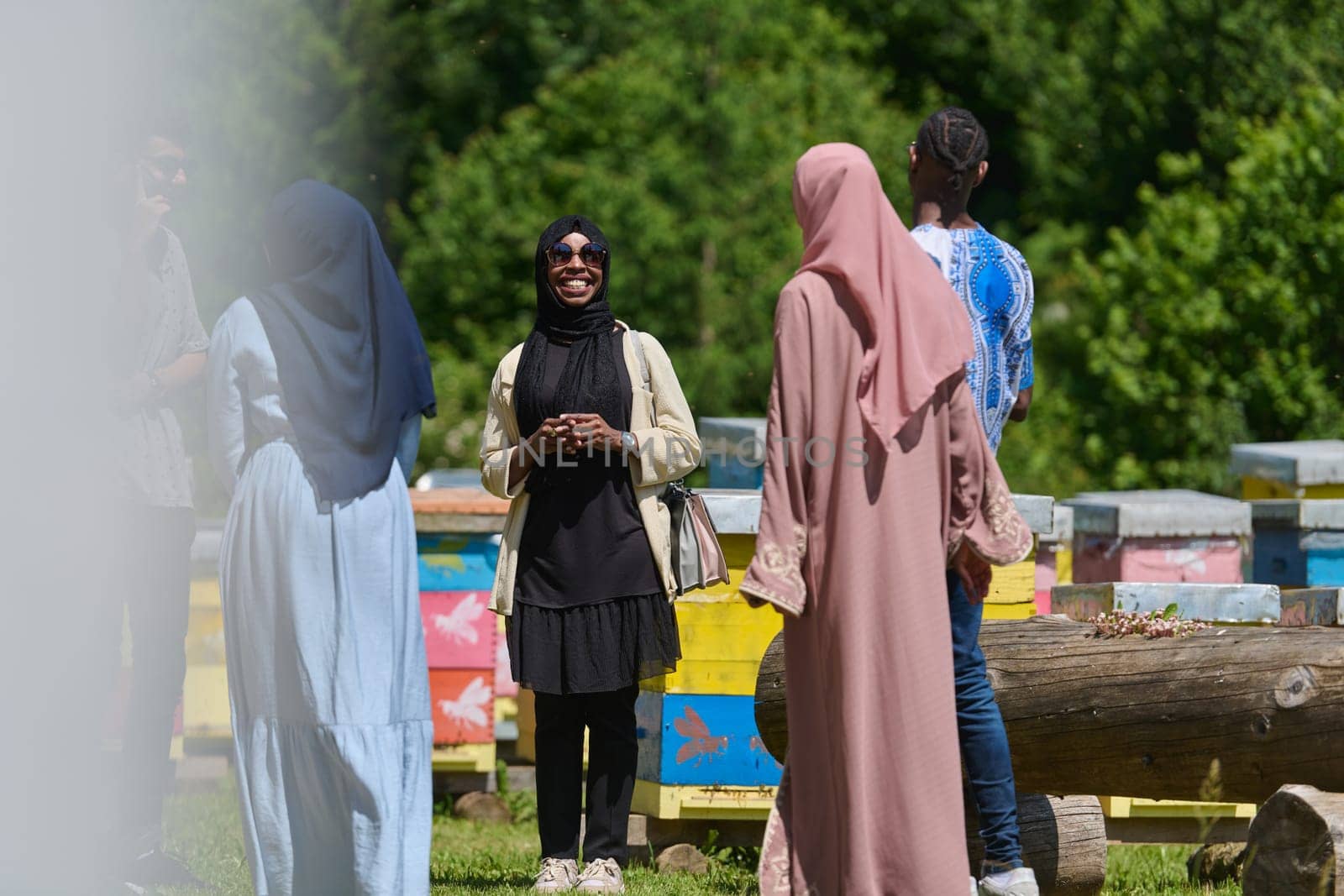 A diverse group of young friends and entrepreneurs explore small honey production businesses in the natural setting of the countryside