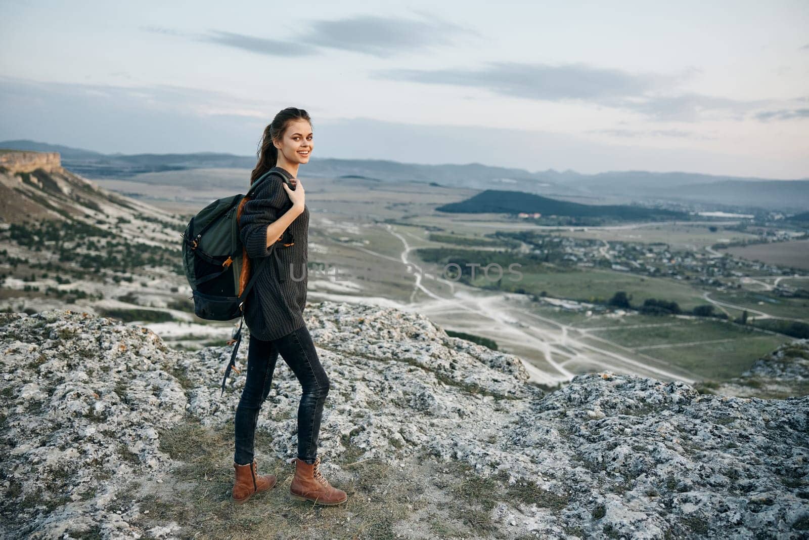 female hiker admires panoramic valley view from mountain summit by Vichizh