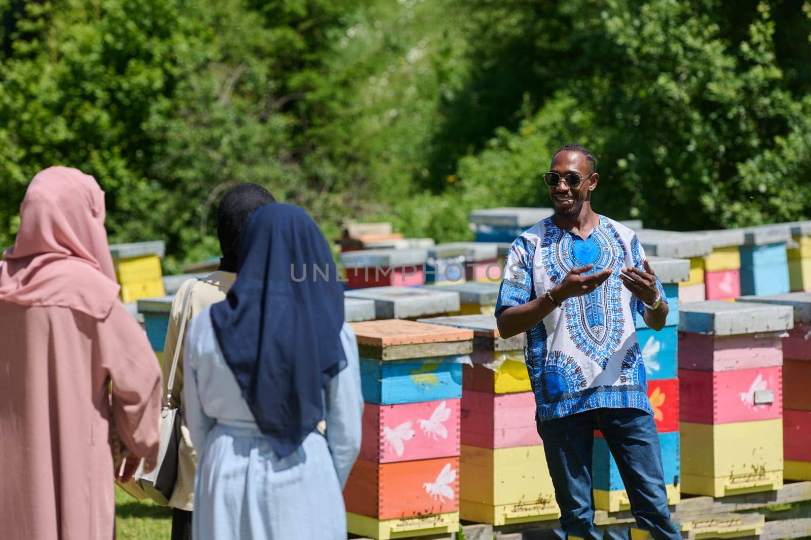 A diverse group of young friends and entrepreneurs explore small honey production businesses in the natural setting of the countryside. by dotshock