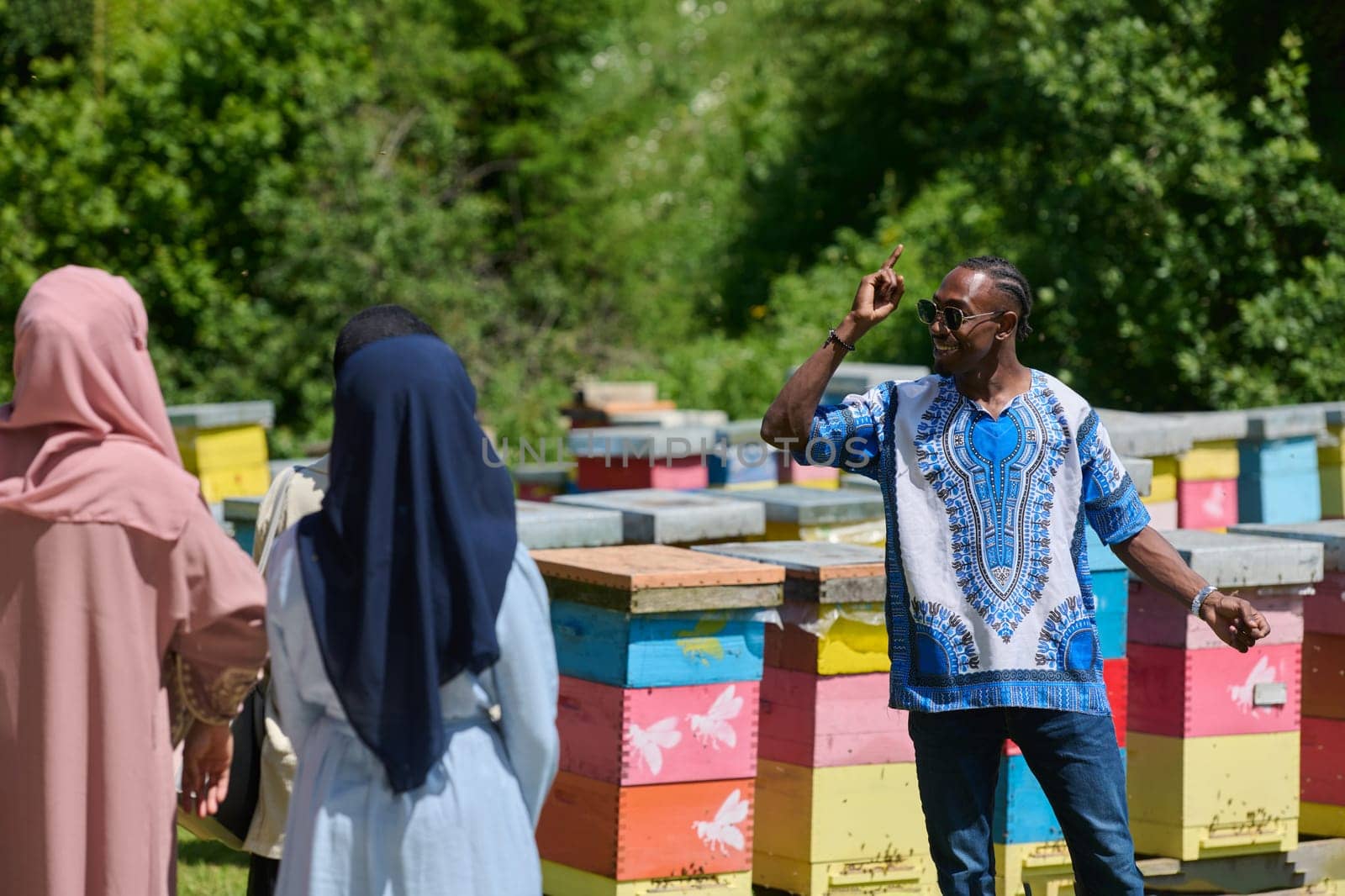 A diverse group of young friends and entrepreneurs explore small honey production businesses in the natural setting of the countryside. by dotshock