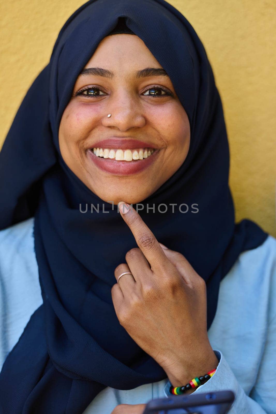 A close-up portrait captures the engagement of a Middle Eastern teenage Muslim girl in her digital world, as she uses a smartphone with focused attention