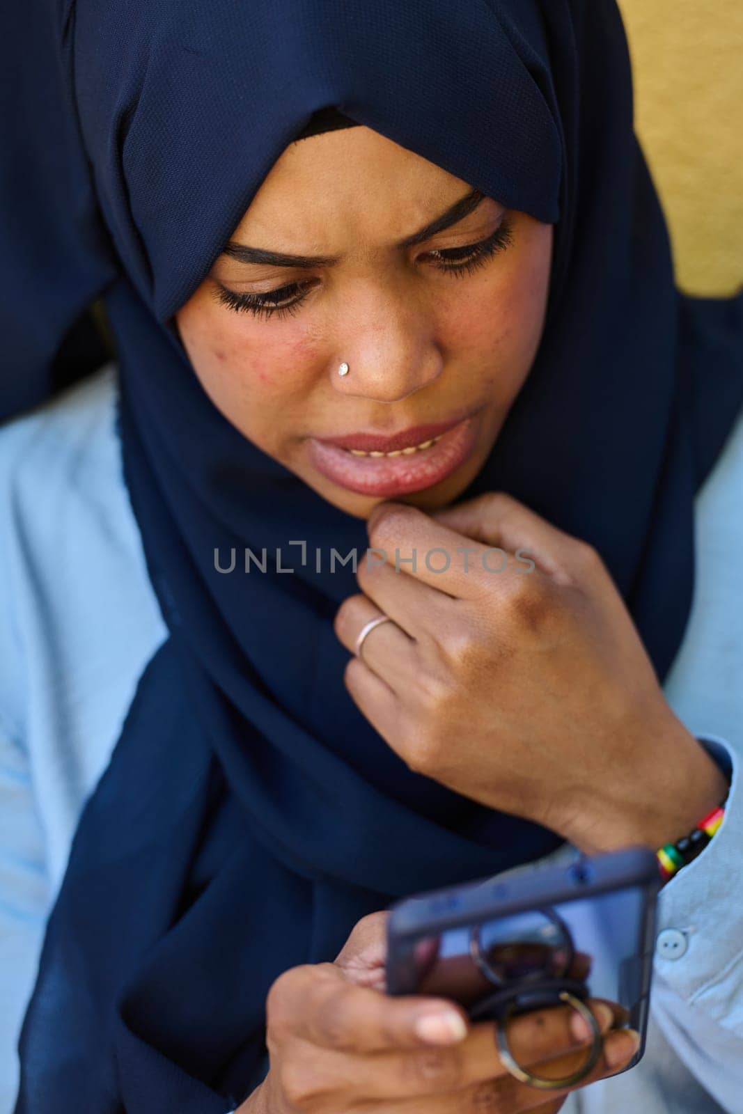 Digital Connection: Close-up Portrait of a Middle Eastern Teenage Muslim Girl Using Smartphone by dotshock