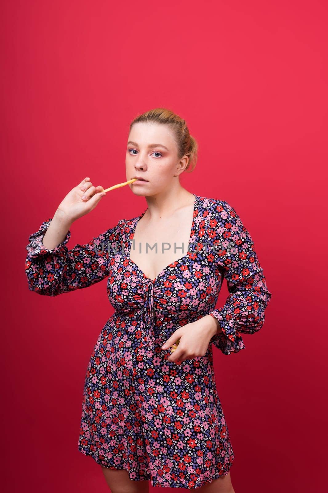 Young beautiful slender female eating a french fries. Concept of un healthy fat junk and healthy food