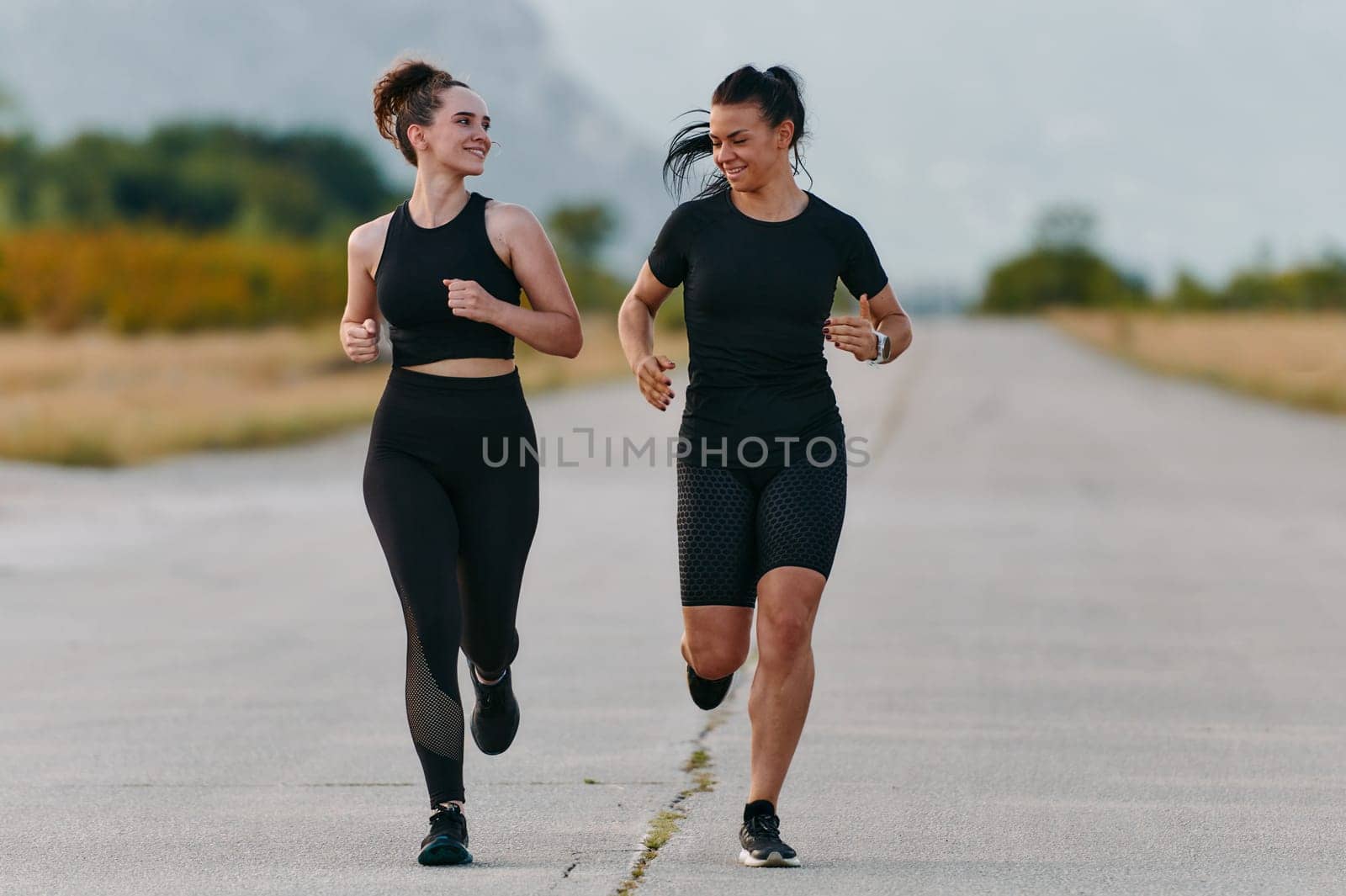 Two friends jog side by side on a sunny day, strengthening their bodies for life's extreme challenges, embodying the power of friendship and determination