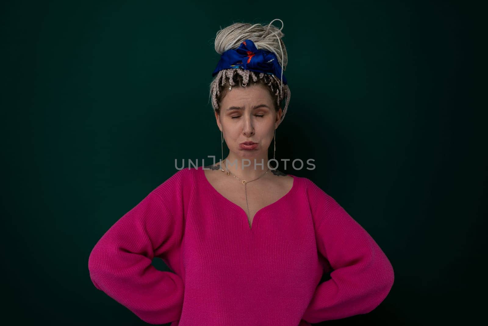 A woman wearing a pink top and a blue bow headband poses for a photo.