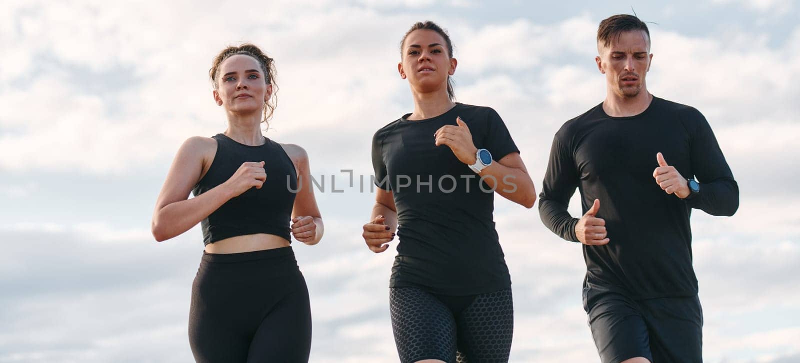 A professional athletic team as they train rigorously, running towards peak performance in preparation for an upcoming marathon.