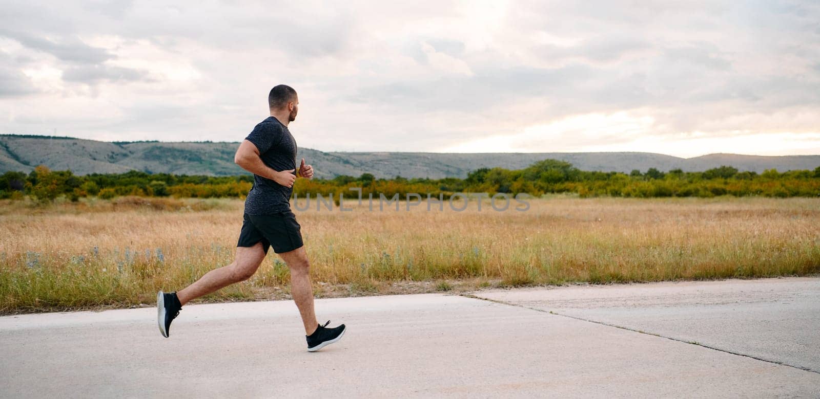 Athletic Man Jogging in the Sun, Preparing His Body for Life's Extreme Challenges by dotshock